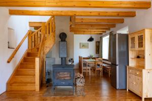 a kitchen and dining room with a stove and stairs at chalupa Pelechy in Kowářow