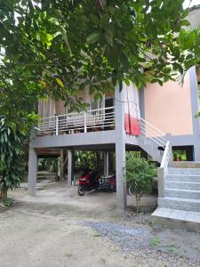 a building with a motorcycle parked in front of it at Cozy Modern House, Top Spot in Baan Tai