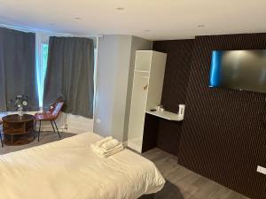 a bedroom with a bed and a tv on a wall at Croft Hotel in Leicester