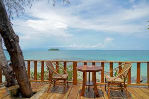 
a wooden bench sitting on top of a sandy beach at Tree House Bungalows in Koh Rong Island
