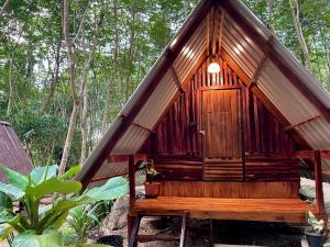 Ban Pha Saeng LangKhao Phang Camping的森林中带长凳的小小屋