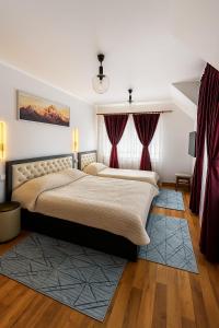 a bedroom with a large bed with red curtains at Casa cu brazi in Porumbacu de Sus