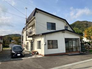 a car parked in front of a house at KeNJIRO HOUSE in Oshirabetsu