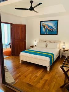 a bedroom with a bed and a ceiling fan at Ralla Nilaveli in Nilaveli +23 photos