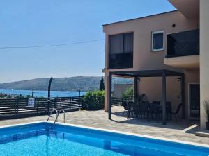 a villa with a swimming pool and a house at Apartman Avila in Marina