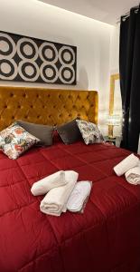 a red bed with towels and pillows on it at Borbon Home luxury rooms & SPA in Palermo +114 photos