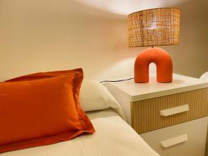 a bedroom with a bed with an orange pillow and a lamp at Comeback Sweet Summer Day in Torrenueva +7 photos