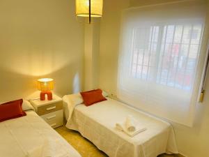 a small room with two beds and a window at Comeback Sweet Summer Day in Torrenueva