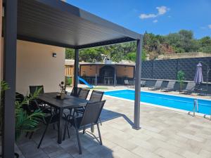 a patio with a table and chairs and a pool at Apartman Avila in Marina