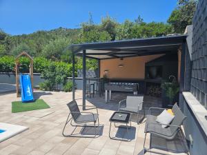 a patio with chairs and a table and a grill at Apartman Avila in Marina +29 photos