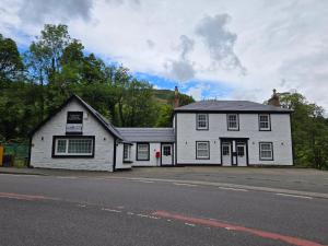 a white building on the side of a street at Stlll Brae Apartment in Tarbet