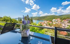 a view from the balcony of a villa with a vase with purple flowers at Nice Apartment In Rabac With Wifi in Rabac