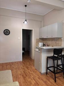 a kitchen with white cabinets and a table and chairs at Matinas House in Neos Panteleimonas