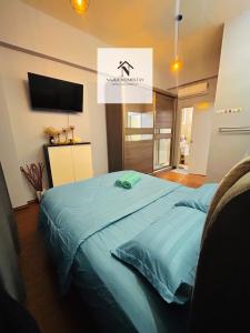 a bedroom with a blue bed with a flat screen tv at Najla Homestay in Sandakan +9 photos
