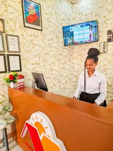 a woman standing behind a counter in a store at Mamucha Grand Lodge in Arusha