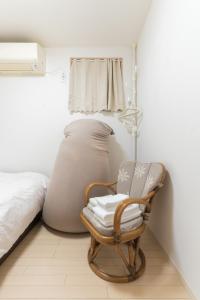 una camera da letto con una sedia accanto a un letto di Direct Access to Umeda Private Stay for 3 Guests ad Osaka