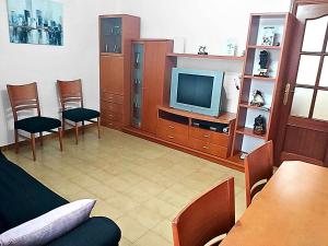 a living room with a tv and a table and chairs at Arcadia Centro de Andalucía in Encinas Reales