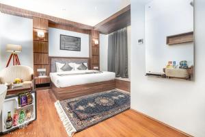 a hotel room with a bed and a refrigerator at The Stay Villa in Srinagar +2 photos