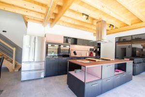una cucina con elettrodomestici in acciaio inossidabile e soffitti in legno di Le sechoir a Grand Brassac