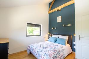 una camera da letto con un letto con una parete blu di Le sechoir a Grand Brassac Altre 22 foto