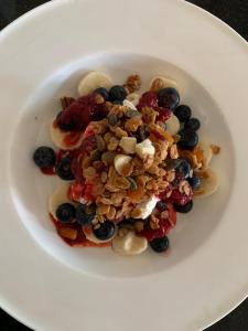 a white plate with fruit and nuts on it at The Old Rectory in Brackley