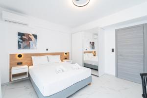 a white bedroom with a bed and a mirror at Emerald Island Residential Complex in Skala Rachoniou +60 photos