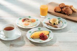 a table with plates of breakfast food and a cup of coffee at The Royal Park Hotel Iconic Tokyo Shiodome in Tokyo