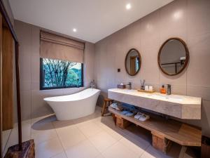 a bathroom with a tub and a sink and mirror at Accommodation Shanlijian Holiday Homestay in Mount Siguniang +55 photos