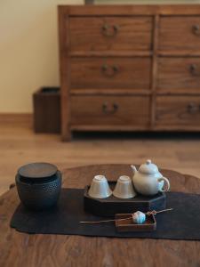 a tray with a tea set and a bowl on a table at Accommodation Shanlijian Holiday Homestay in Mount Siguniang