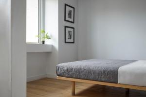 um quarto branco com uma cama e uma janela em Standard Suite by Acropolis Cozy Suites em Atenas