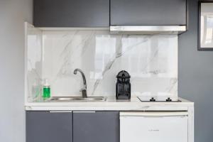 uma cozinha branca com um lavatório e um chuveiro em Standard Suite by Acropolis Cozy Suites em Atenas