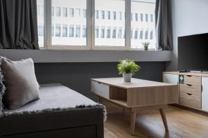 uma sala de estar com um sofá e uma mesa com uma televisão em Standard Suite by Acropolis Cozy Suites em Atenas mais 5 fotografias