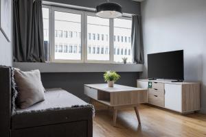 uma sala de estar com uma TV e um sofá em Standard Suite by Acropolis Cozy Suites em Atenas