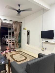 a living room with a couch and a flat screen tv at Cryptohouse Pantai Kelulut in Marang +7 photos