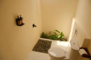 a bathroom with a toilet and a potted plant at Uma Resort Togean in Katupa