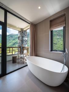 a large white tub in a bathroom with a view at Accommodation Shanlijian Holiday Homestay in Mount Siguniang