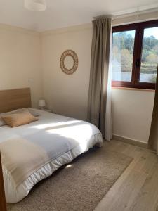 Un dormitorio con una cama grande y una ventana. en Oliveira's Little House, en Caminha