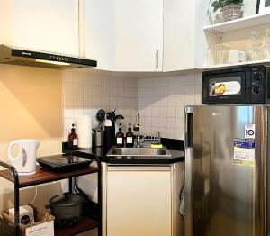 a kitchen with a stainless steel refrigerator and a sink at Avida Towers - Noma CDO in Cagayan de Oro
