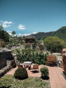 a patio with a table and chairs and mountains at Accommodation Shanlijian Holiday Homestay in Mount Siguniang