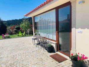 Un patio con una mesa y sillas frente a un edificio. en Oliveira's Little House, en Caminha