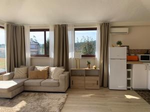 a living room with a white couch and a kitchen at Oliveira's Little House in Caminha