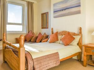 a bedroom with a wooden bed with pillows and a window at Seasider in Whitby +9 photos