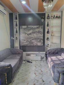 Benin CityにあるBellevette homeのリビングルーム(ソファ2台、絵画付)
