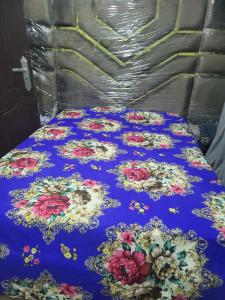 Benin CityにあるBellevette homeのベッド(花の上に青い毛布付)