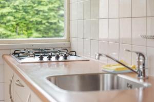 a kitchen with a sink and a stove and a window at NL - Oostmahorn 149 in Anjum