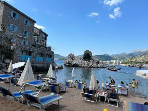 a group of chairs and people on a beach at Studio Sea View Steps to Przno beach w Parking Villa Olive in Pržno