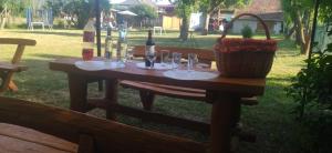 a picnic table with wine bottles and glasses on it at KOÓS VENDÉGHÁZ in Uppony