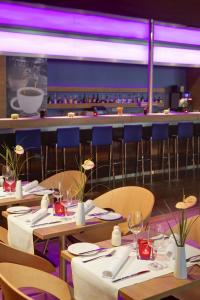 a restaurant with tables and chairs and a bar at IntercityHotel Bonn City in Bonn