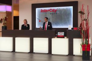 two men are standing at a reception desk at IntercityHotel Bonn in Bonn