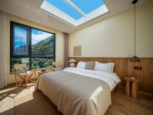 a bedroom with a large bed with a large window at Accommodation Shanlijian Holiday Homestay in Mount Siguniang